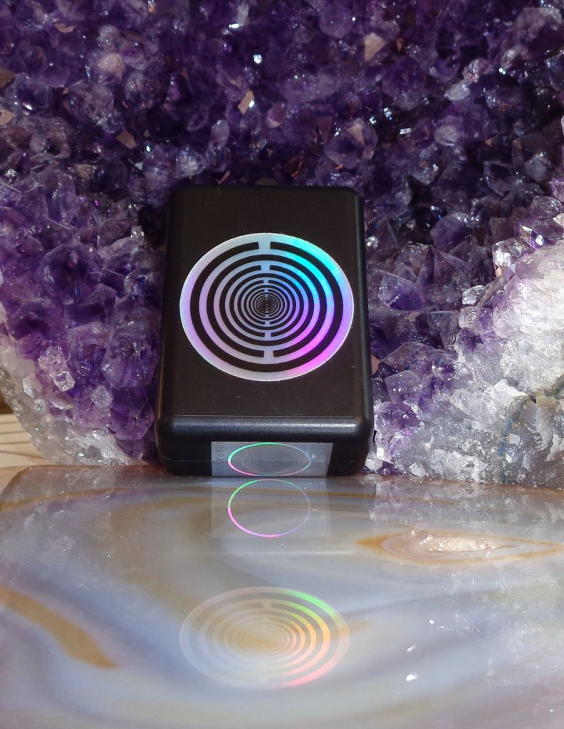 Prana-Frequenz-Cube-Mini 7,83 Hz Resonanz: Schwarzer Cube mit holografischem Kreissymbol auf Amethystkristallen