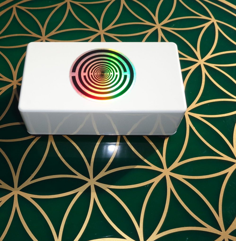 Prana-Frequenz-Cube-XL +Hologramm: Weißer Prana-Frequenz-Cube mit Hologramm auf grüner Blume des Lebens-Matte
