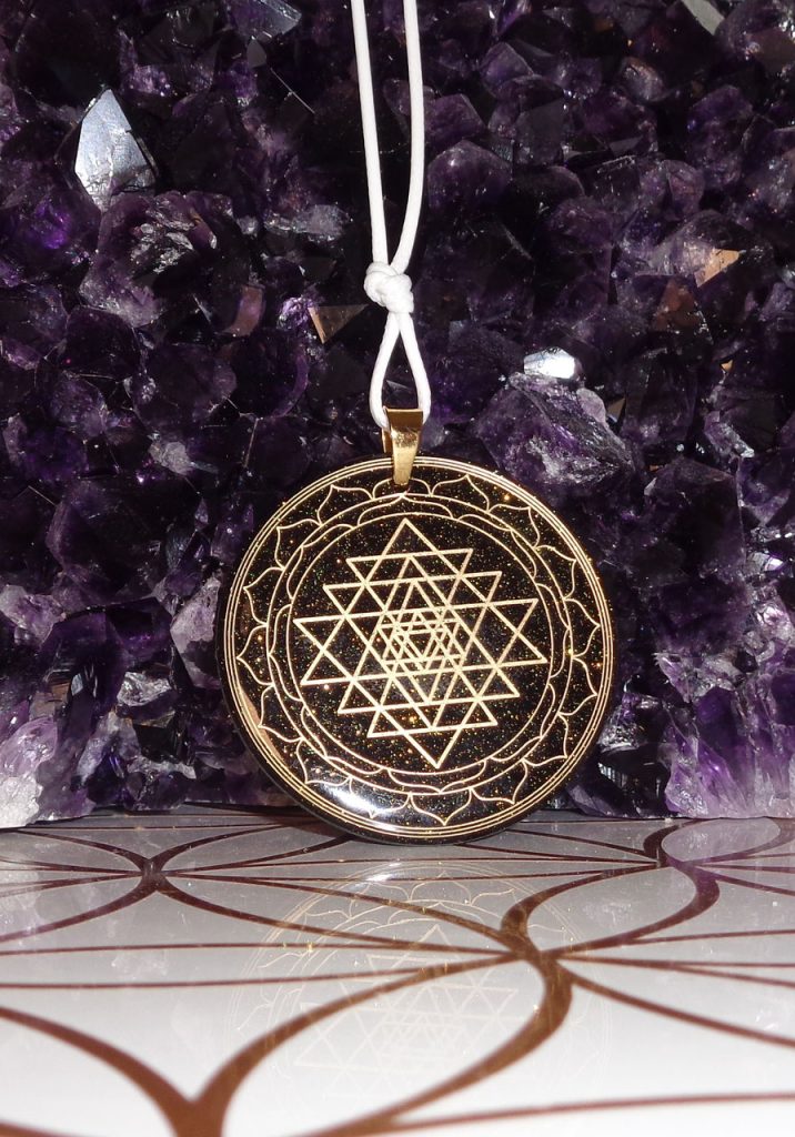 Runder Sri-Yantra-Orgon-Anhänger in Schwarz-Gold vor Amethysten, Draufsicht