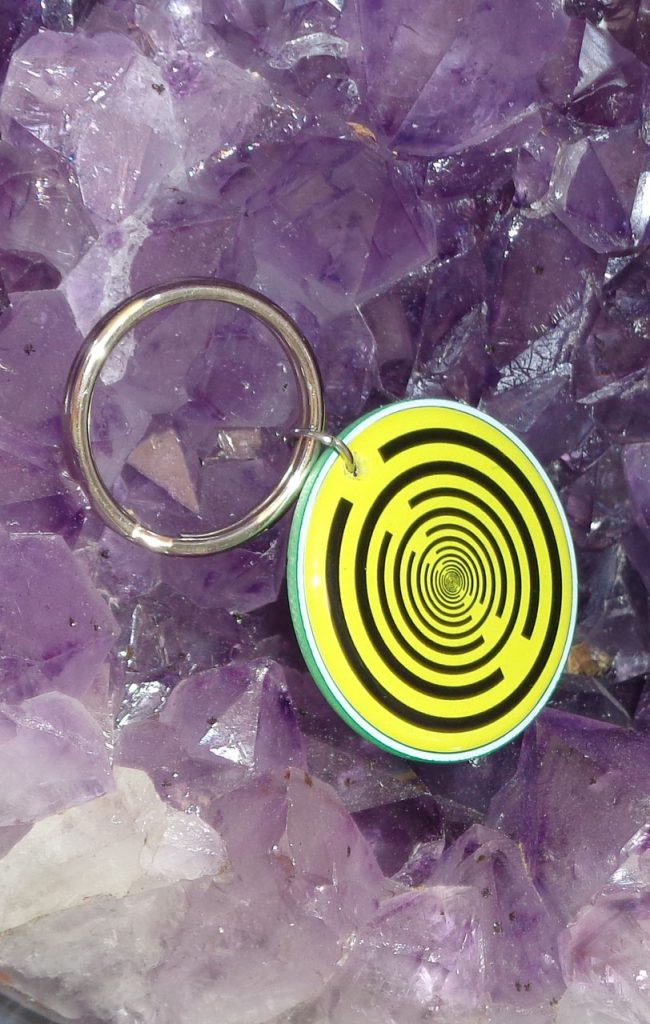 Tier-Anhänger 3D-Button +SK-Tec: Runder Anhänger mit gelbem Spiralmuster auf Amethystkristall